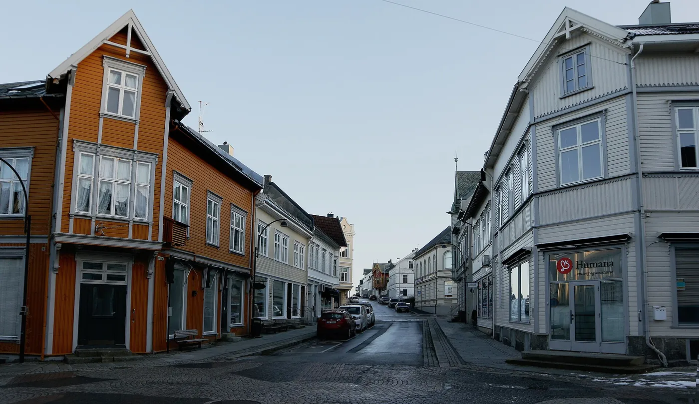 Storgaten i Farsund med trehusbebyggelse i gult og hvitt